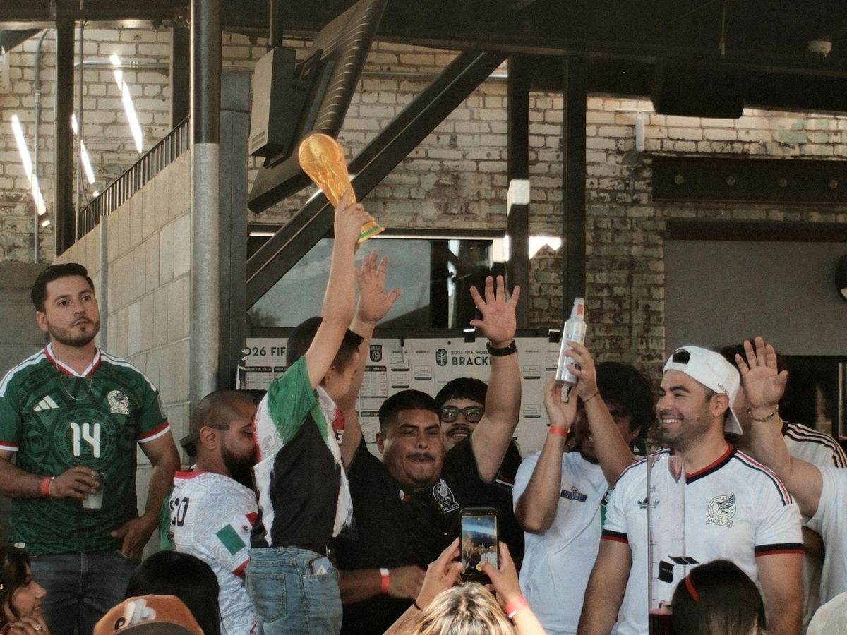 A team lifting a trophy in front of a crowd